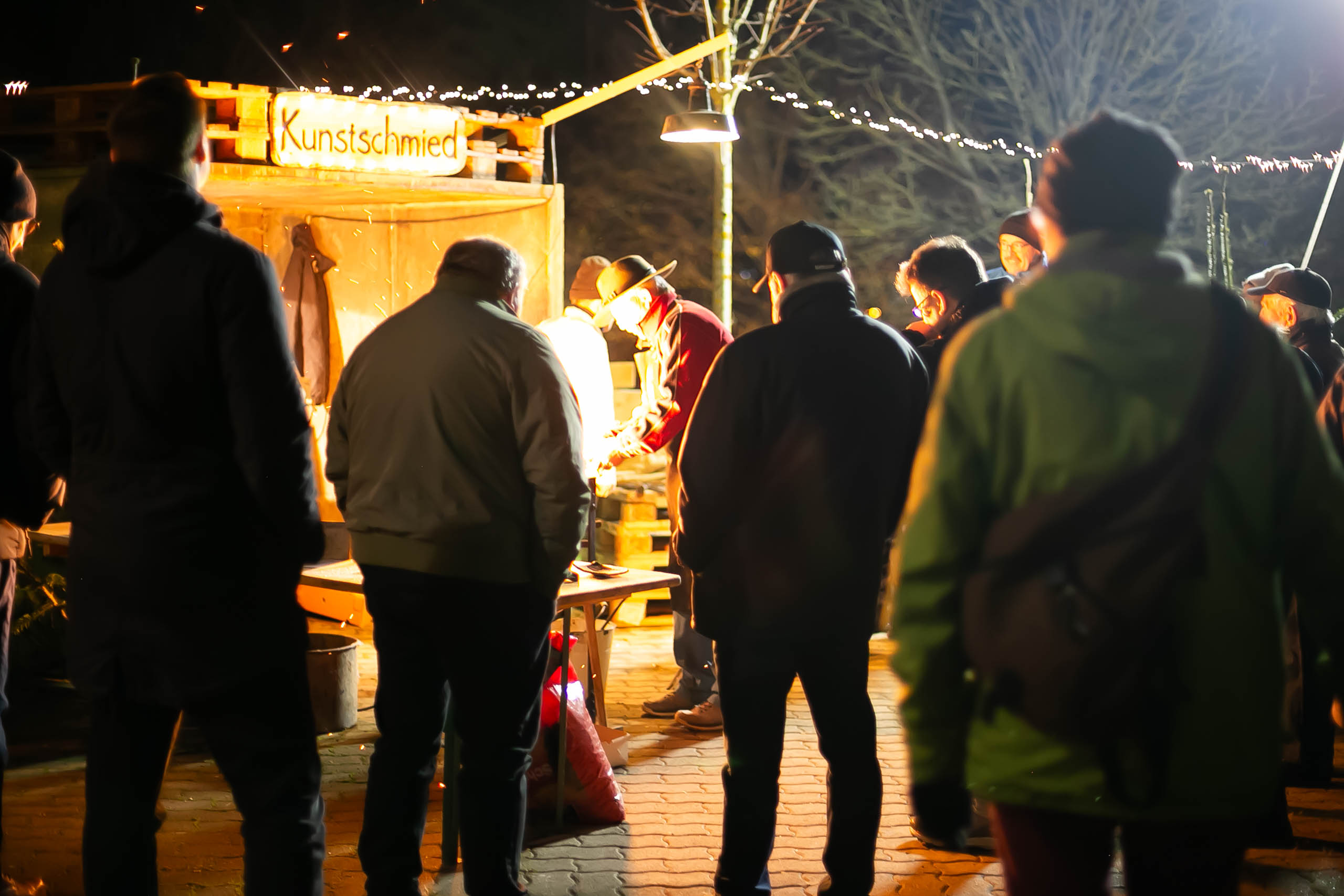 Besucher des Marktes schauen den Handwerkern bei der Arbeit zu.